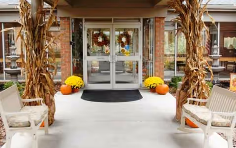 Front entrance of Bickford of Lancaster with glass doors, wreaths, pumpkins, corn stalks, and seating.
