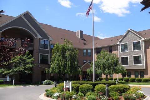 Exterior view of Ecorse Manor Co-op with landscaping and flagpole.