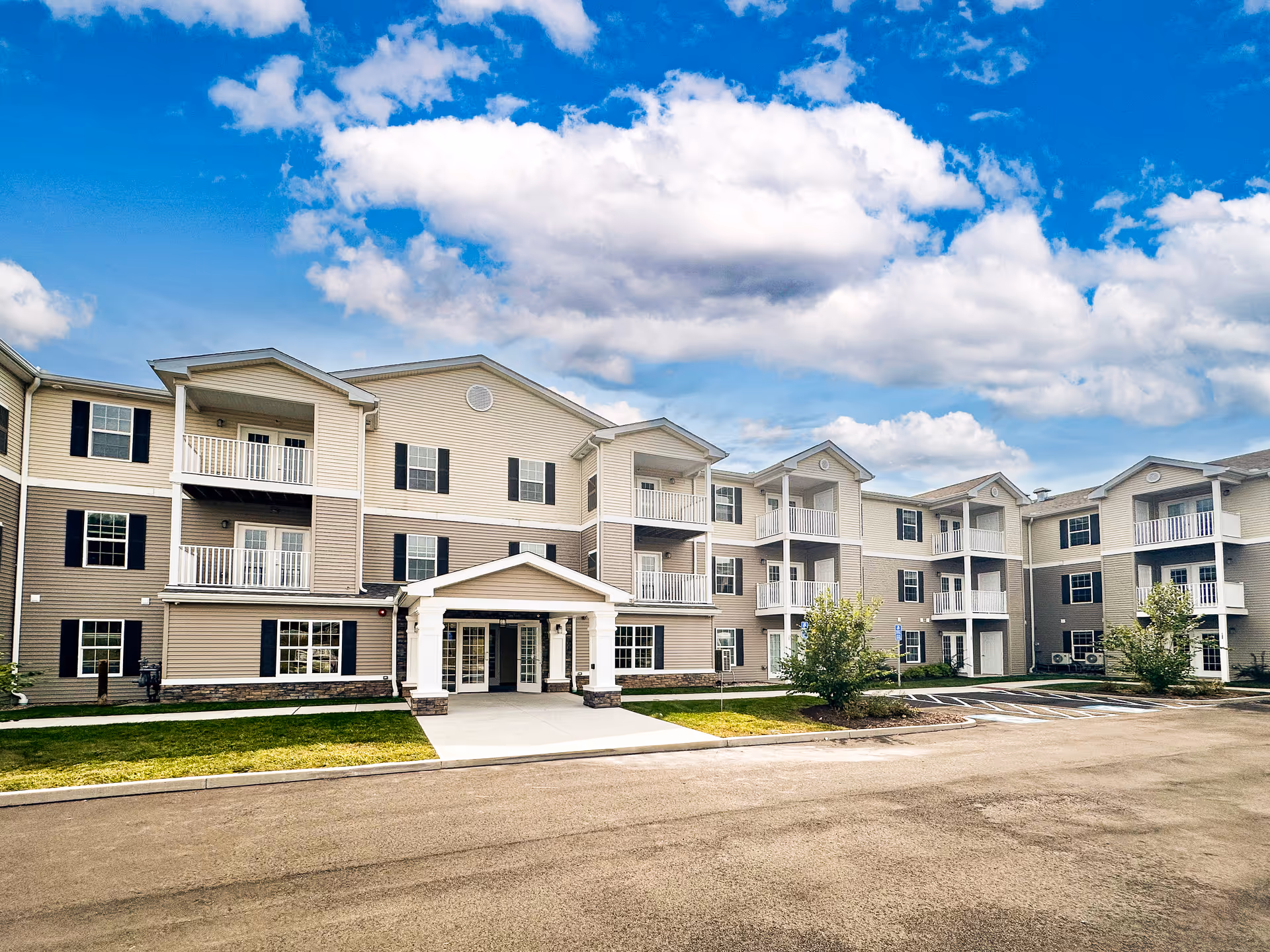 Exterior view of a Connect55+ Manchester senior living building with balconies and entrance.