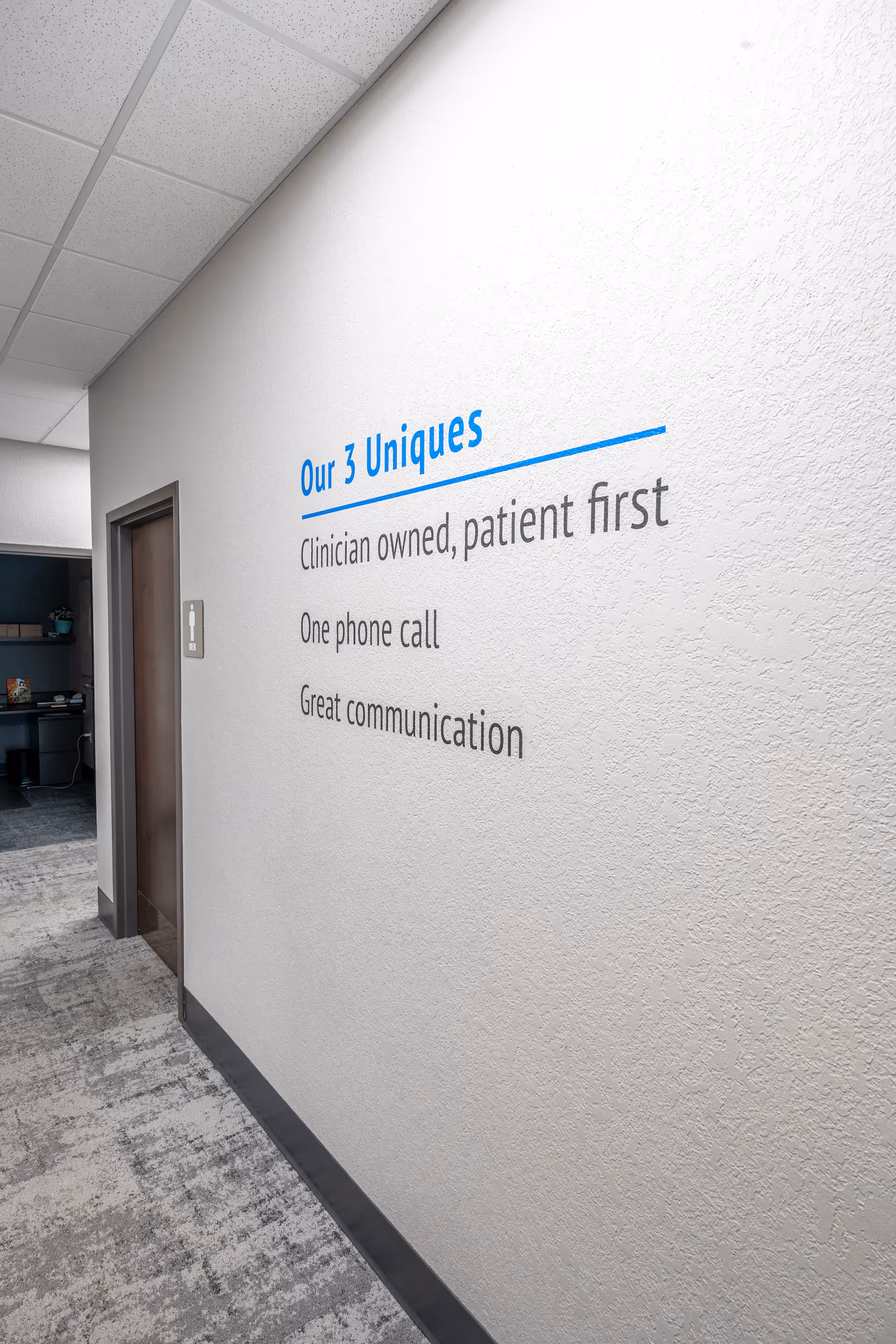Interior hallway with wall sign highlighting clinician-owned, patient-first messaging.
