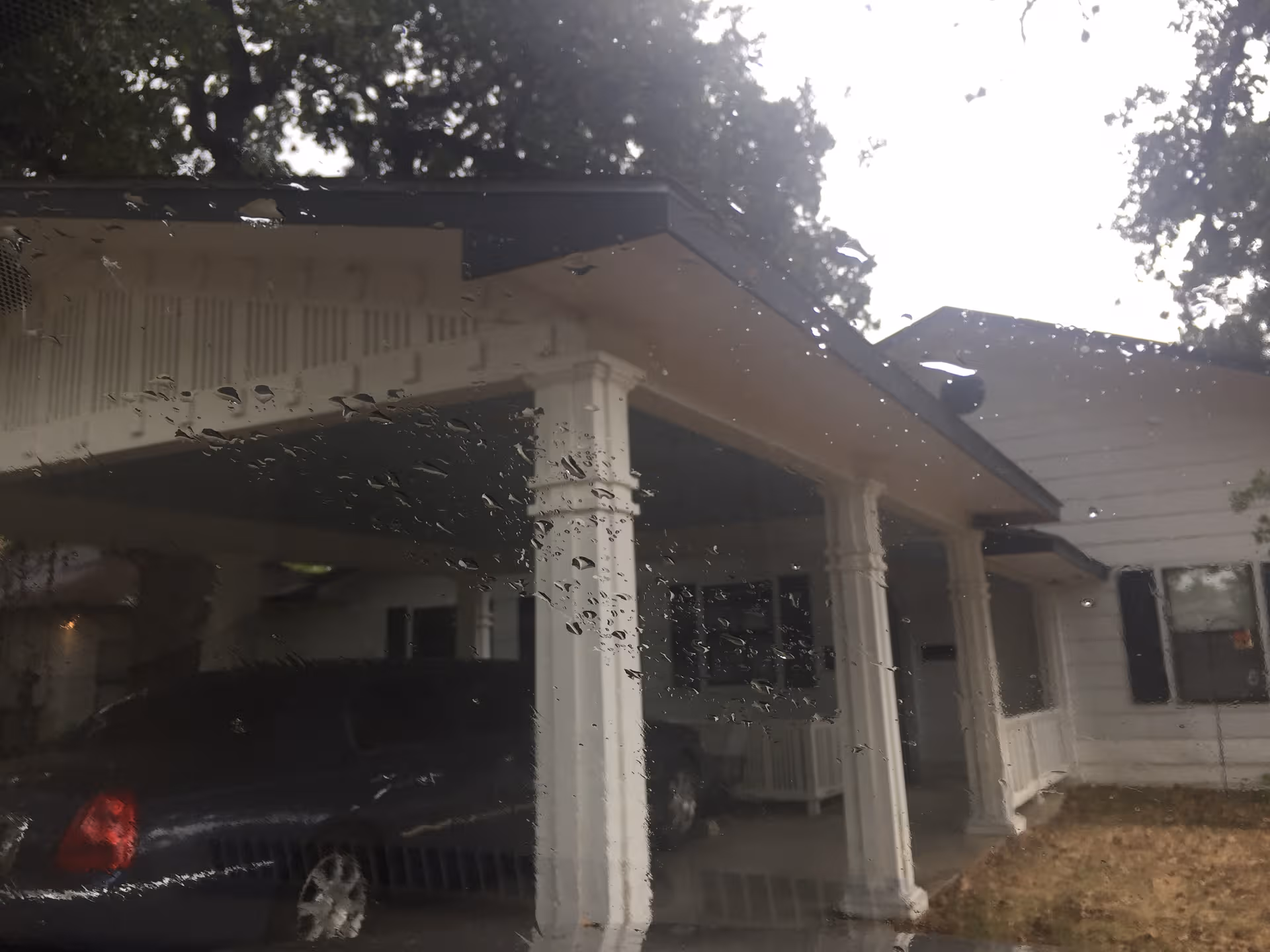 Front exterior of Romberg House Assisted Living, showing white columns, carport, and entrance.