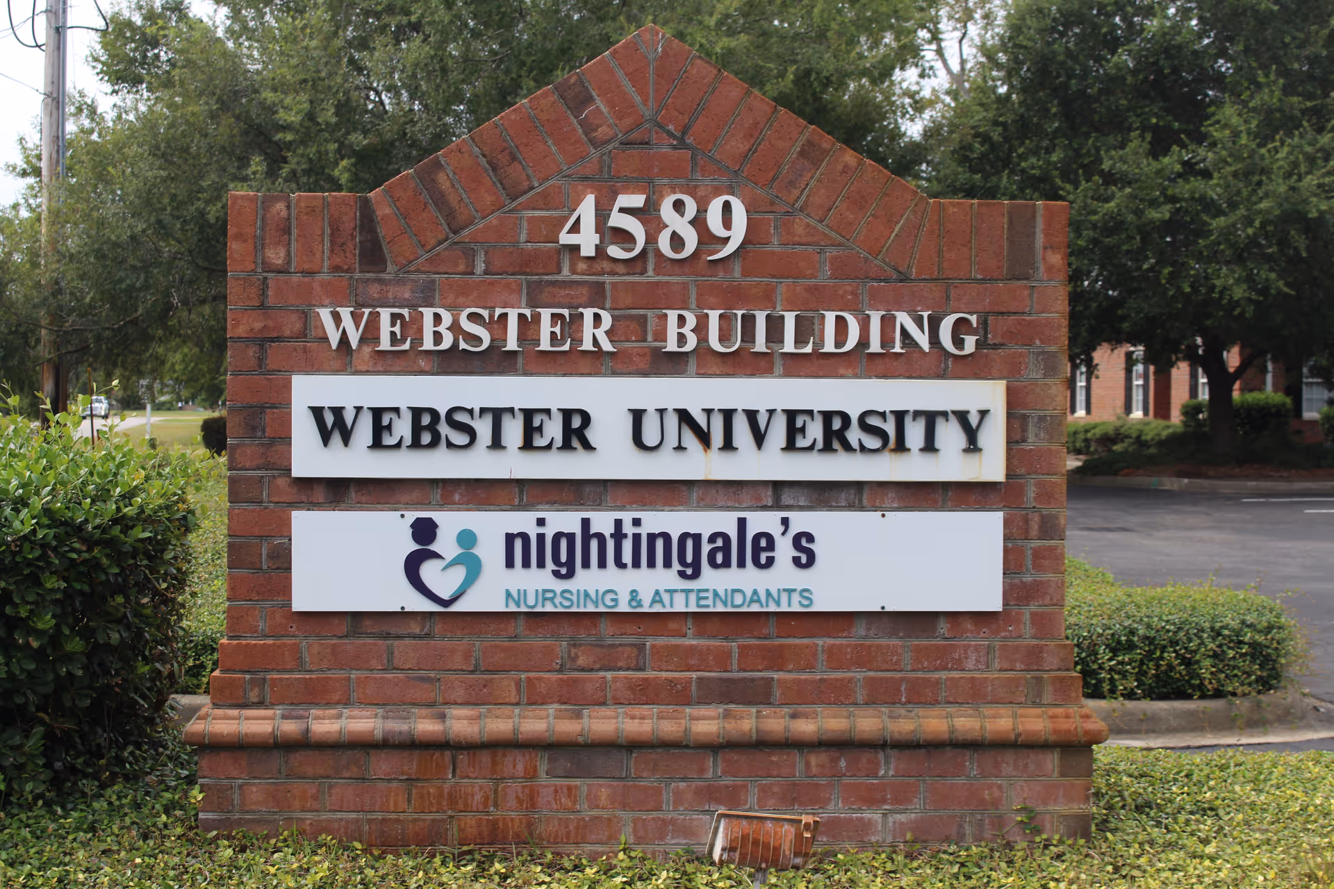 Brick sign displays 4589 Webster Building, Webster University, and Nightingale's Nursing & Attendants logo.