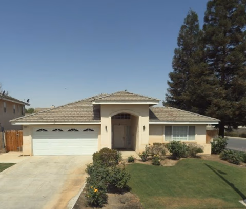 Front view of a single-story building with a two-car garage and green lawn.