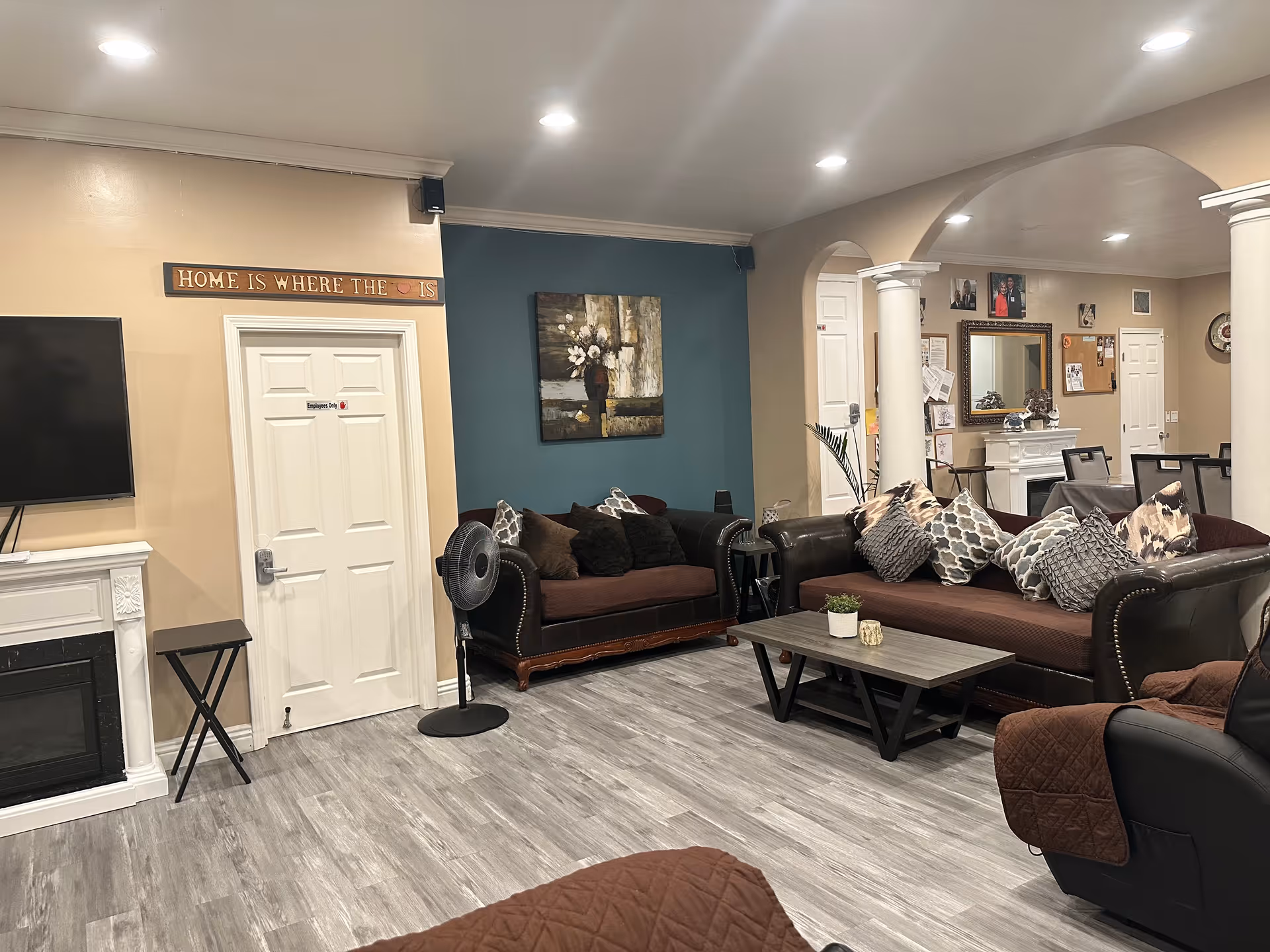 Cozy common living room with leather sofas, pillows, coffee table, and archways.