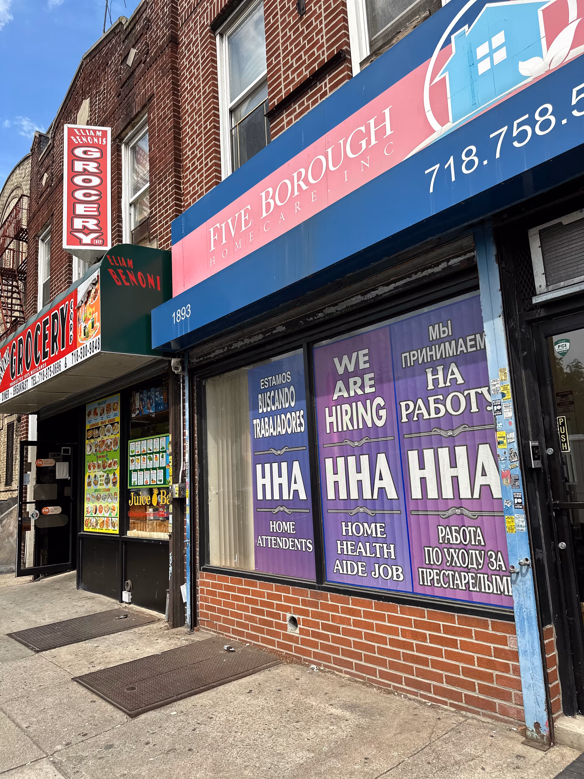 Brick storefronts along a city street featuring Five Borough Home Care sign and hiring posters.
