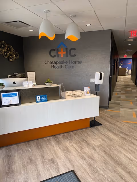 Reception desk in a Chesapeake Home Health Care lobby with logo on wall.