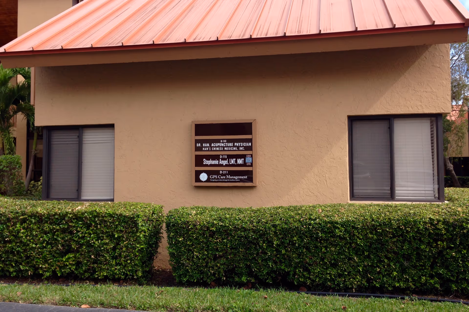 Exterior view of GPS Care Management building with beige walls, red roof, and hedges.
