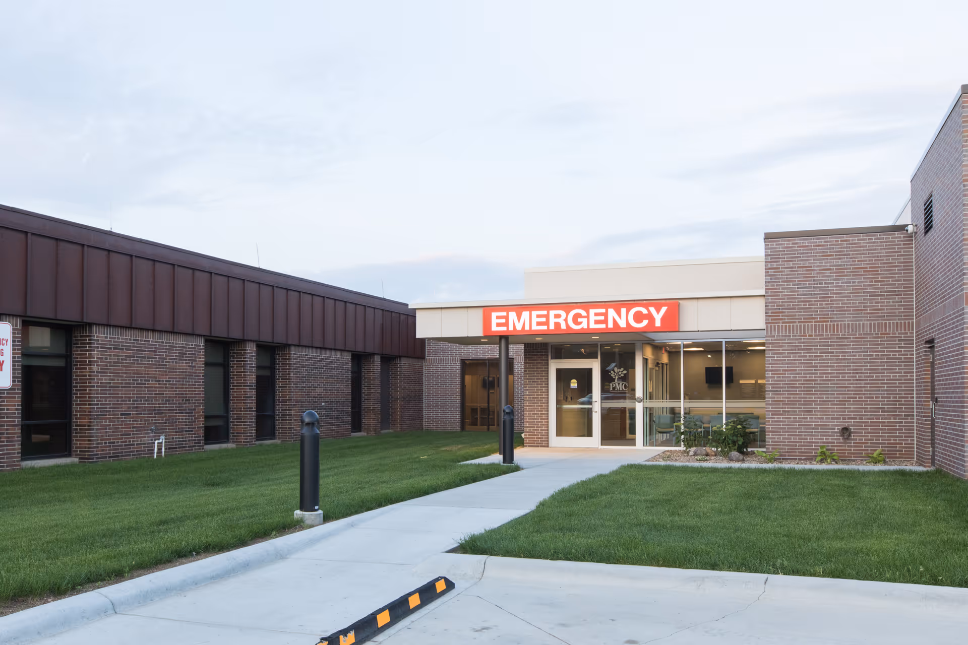 Exterior view of Providence Medical Center emergency entrance with a bright red sign.