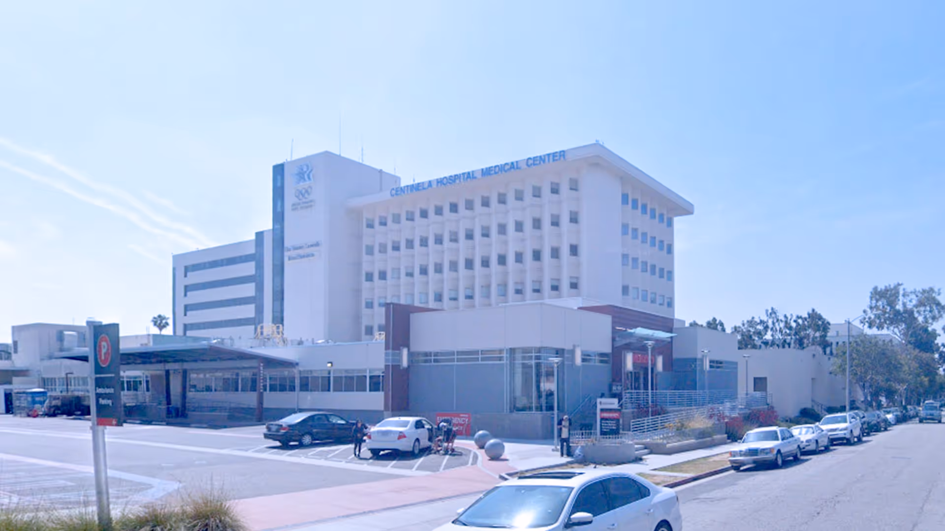 Exterior view of Centinela Hospital Medical Center front entrance with parked cars along the street
