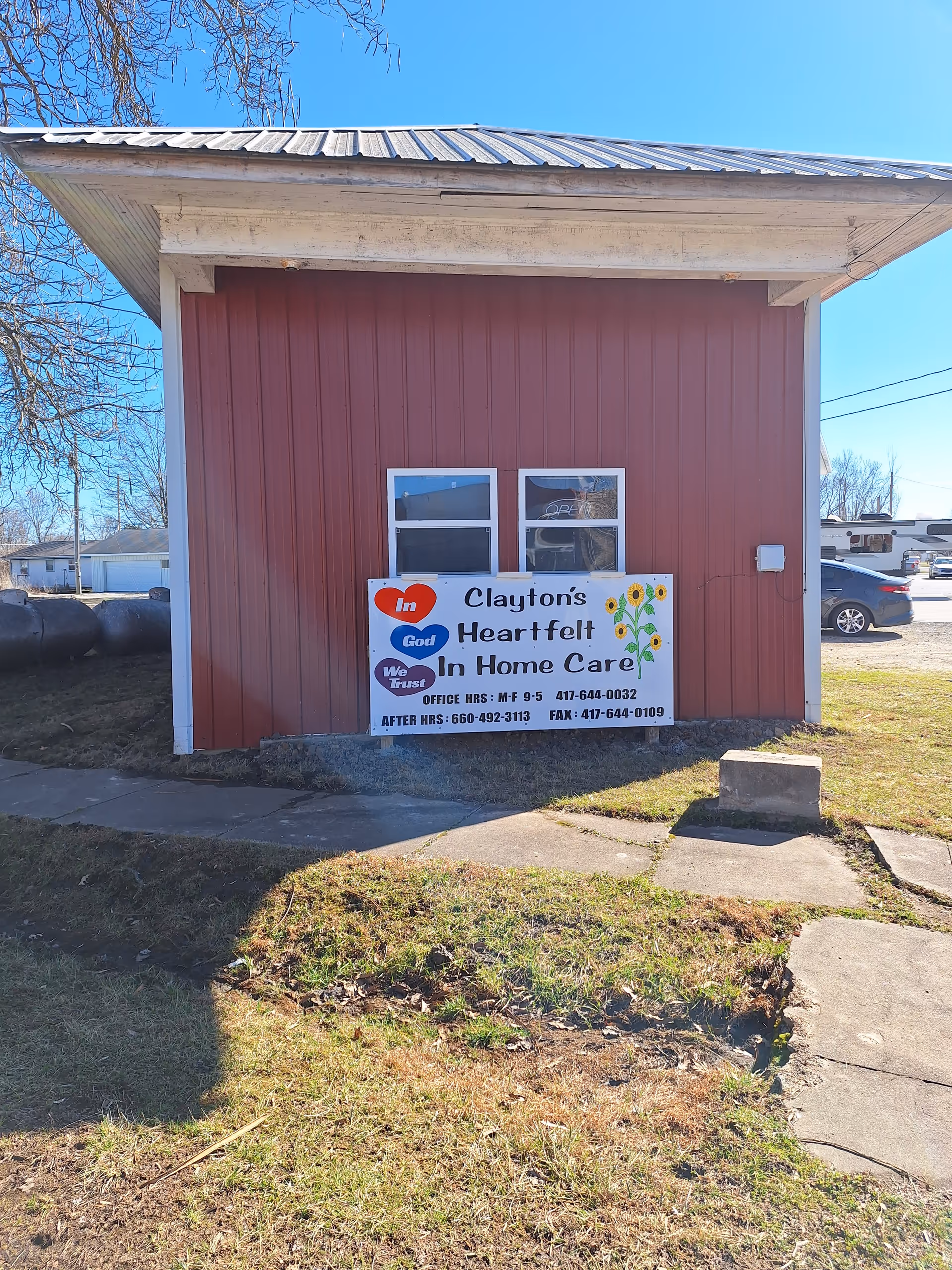 Front view of a red wooden building with a Clayton's Heartfelt In Home Care sign.