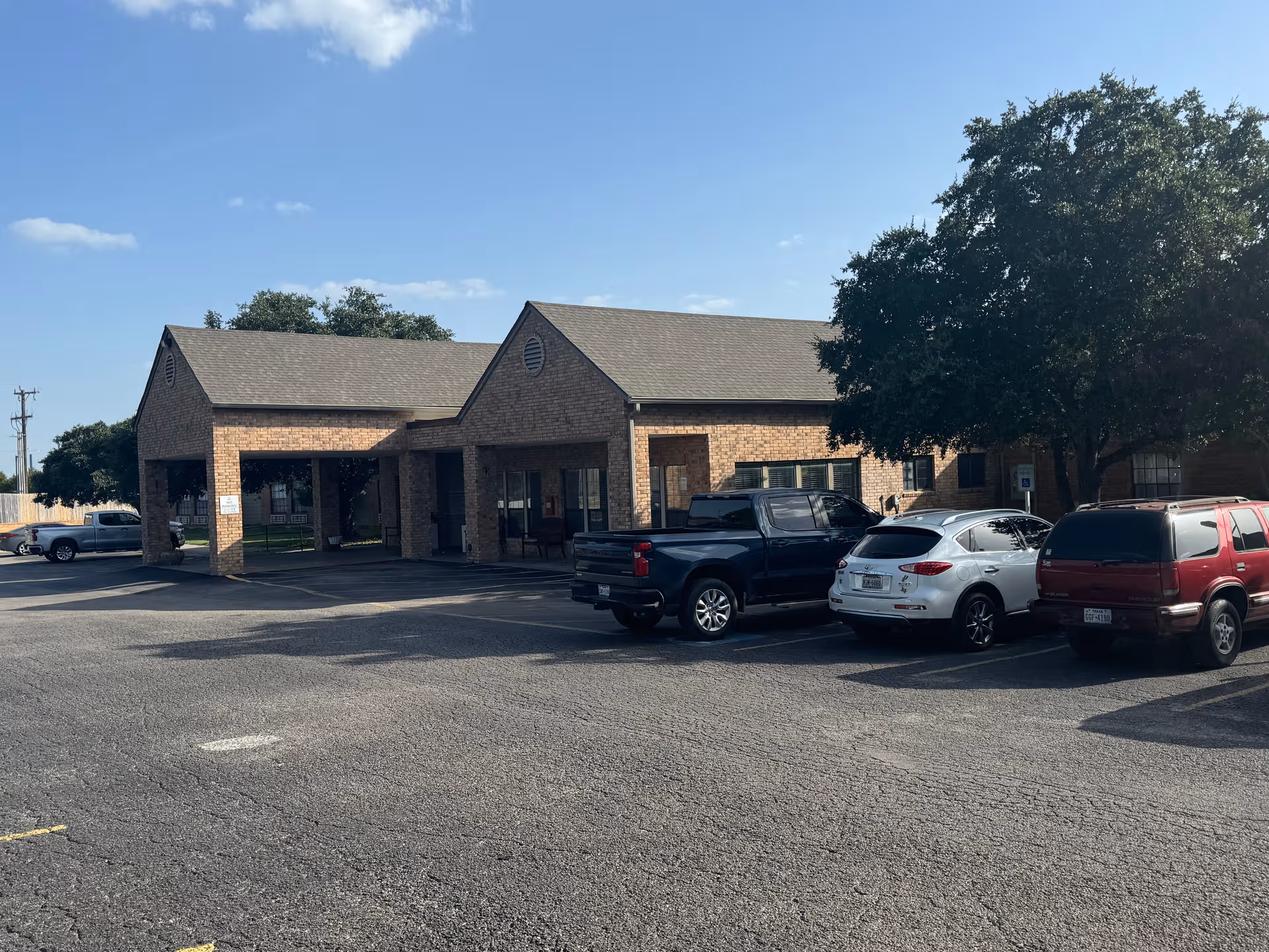Exterior of The Healthcare Center at Patriot Heights with brick facade and parked cars.