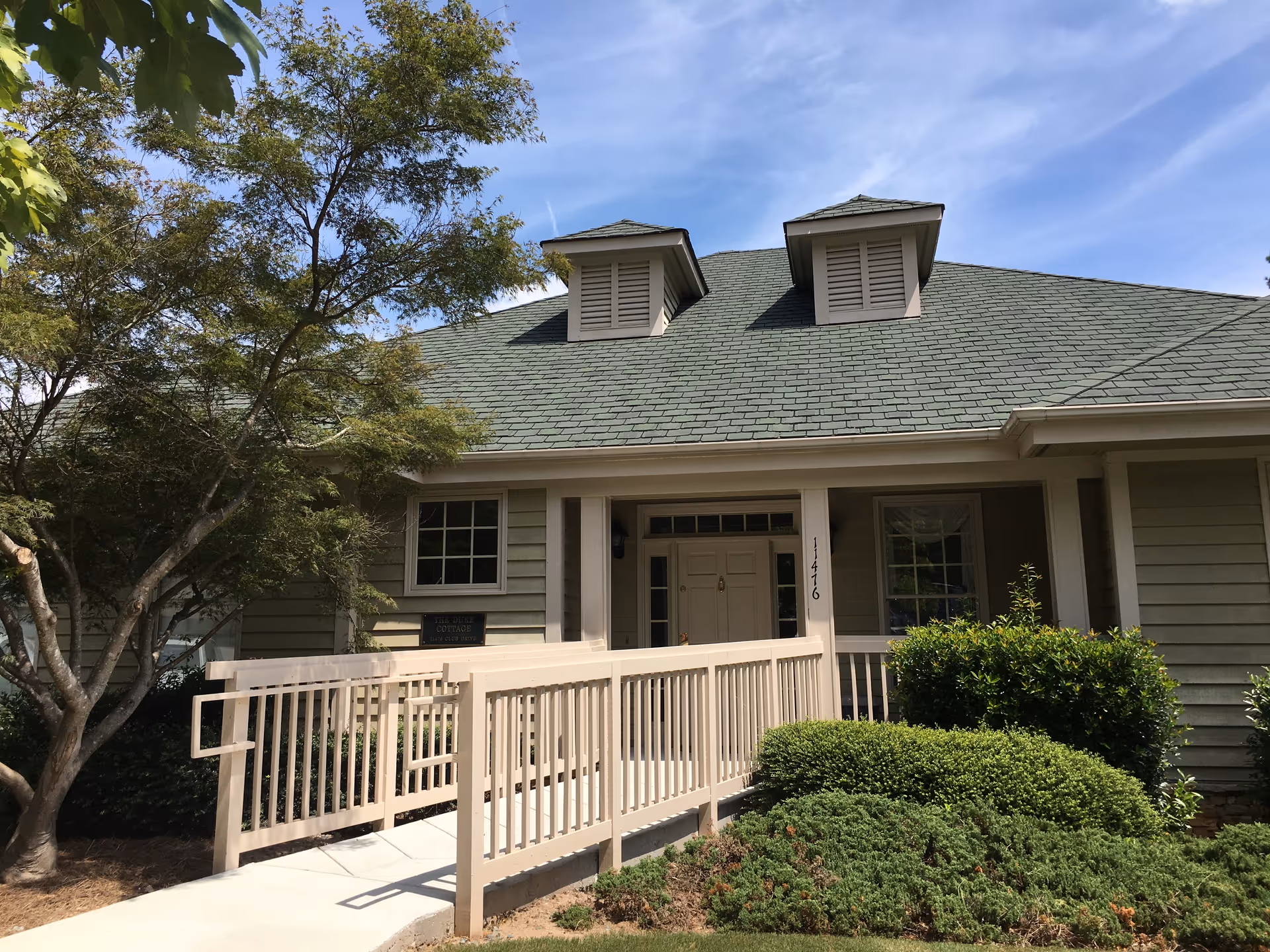 Front view of a single-story assisted living building with a porch and green roof.