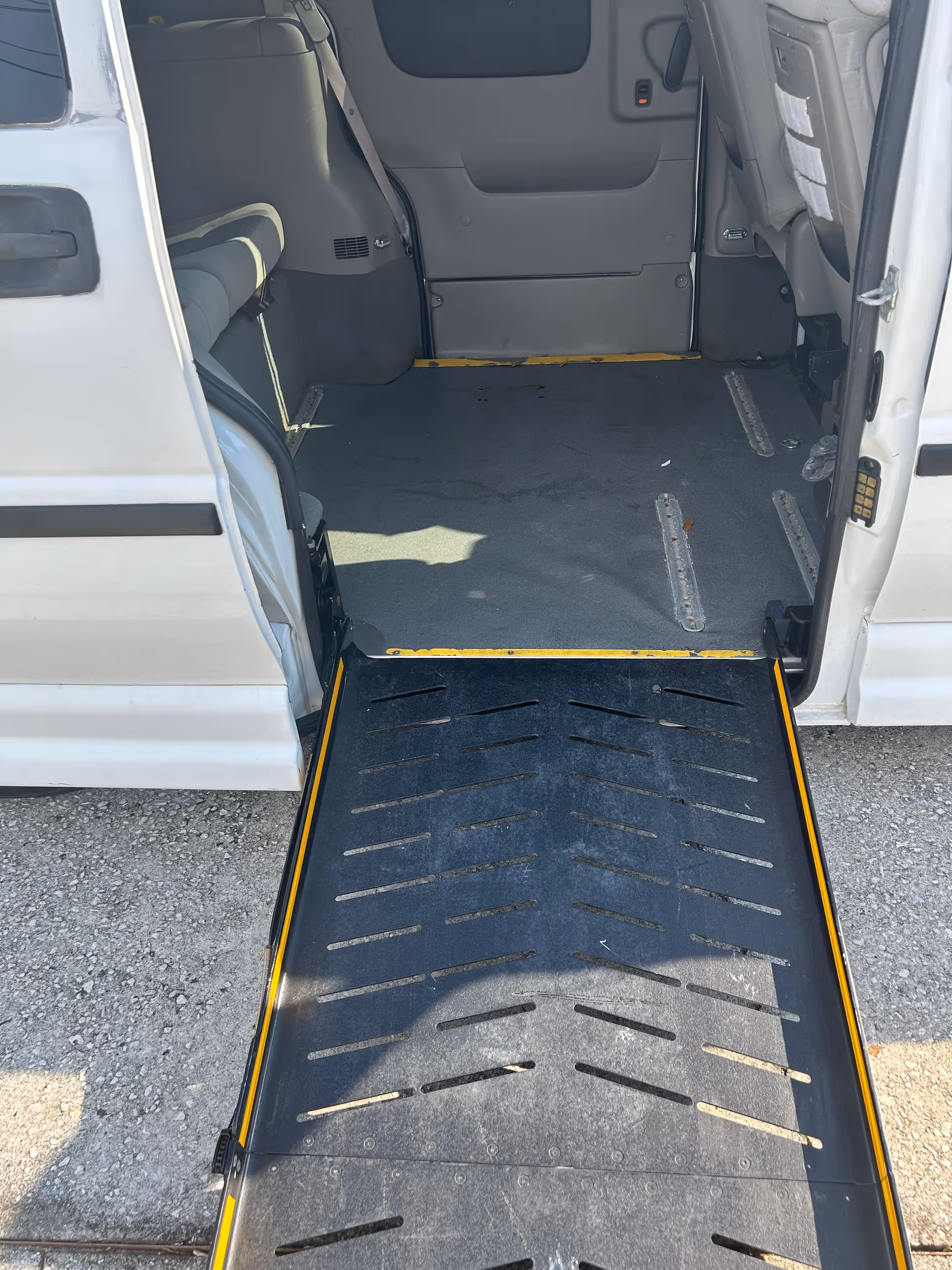 Open van with lowered ramp revealing wheelchair-accessible interior.
