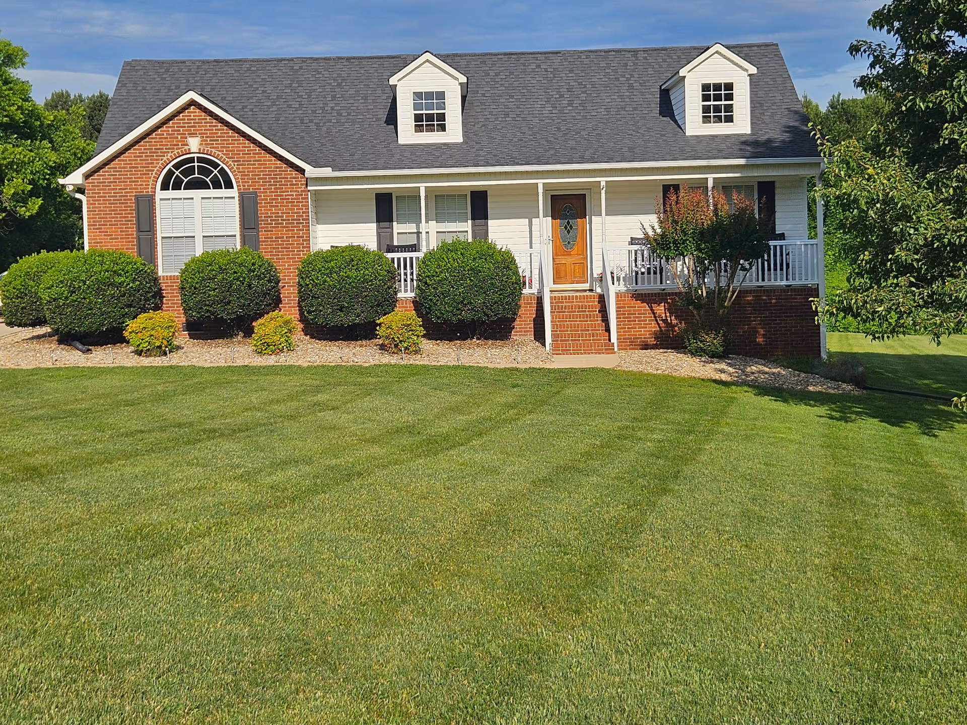 Thalia Gardens Assisted Living exterior: brick building with manicured lawn and shrubs