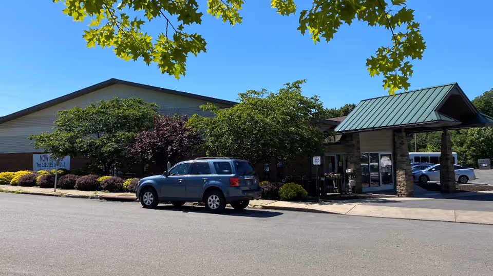 Exterior view of LIFE Butler County senior living facility with entrance canopy and parked SUV.