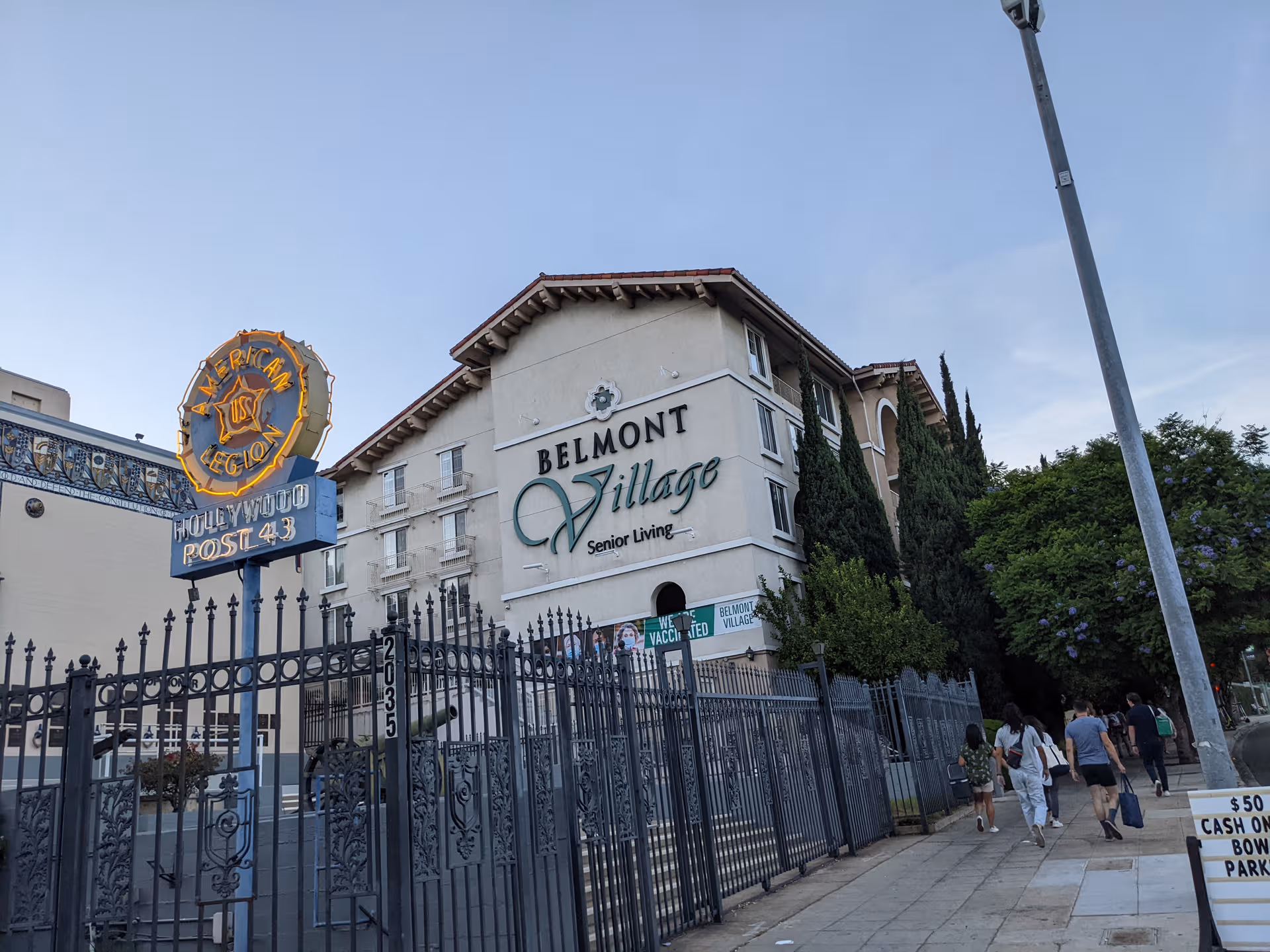 Exterior view of Belmont Village Senior Living Hollywood Hills building with a wrought-iron fence.