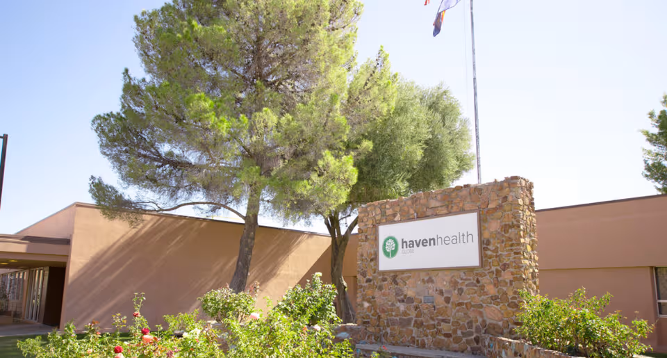 Exterior view of Haven Health Globe facility with stone sign and surrounding trees.