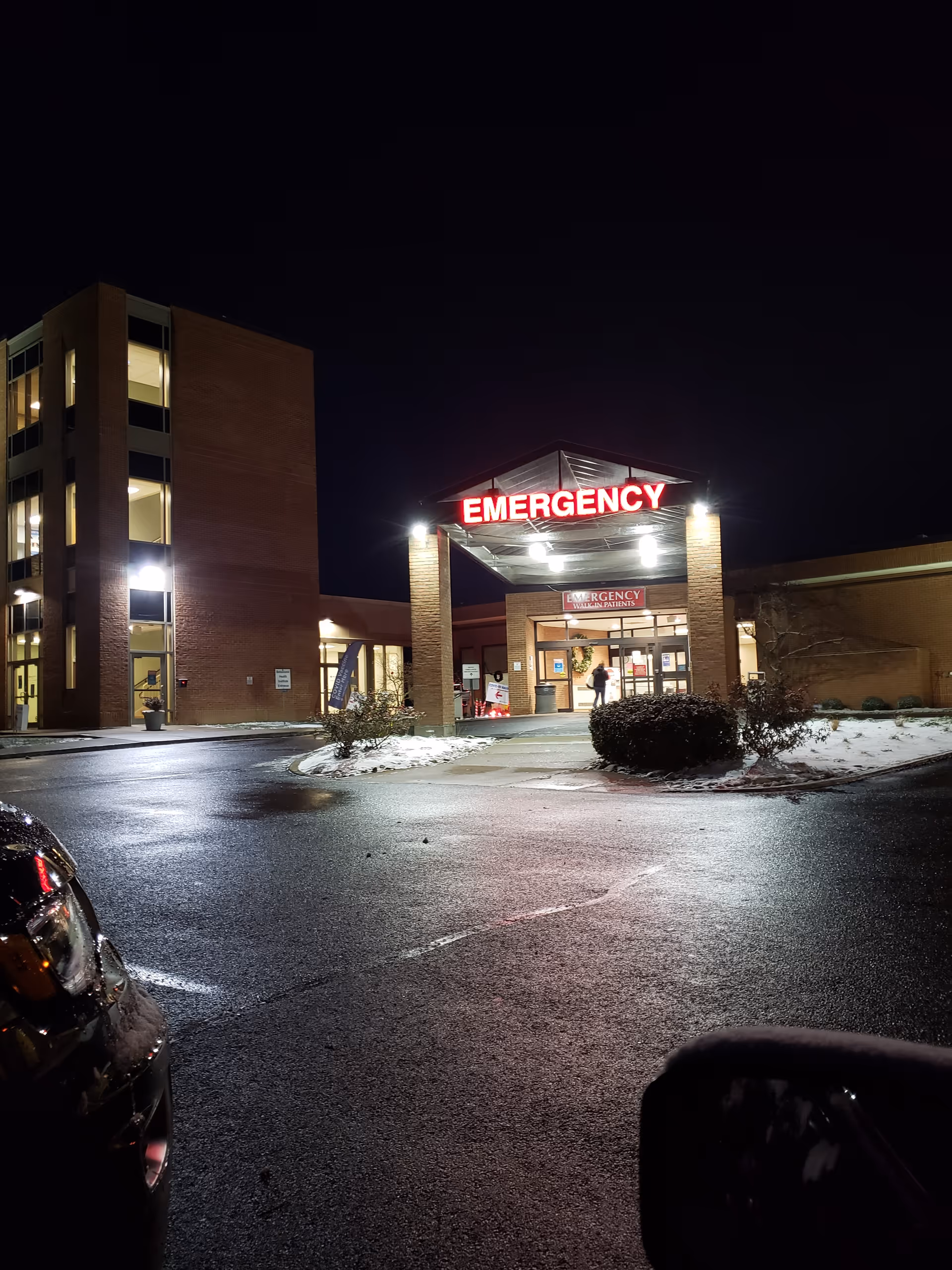 Night exterior of Mercy Health Clermont Hospital emergency entrance with illuminated sign.