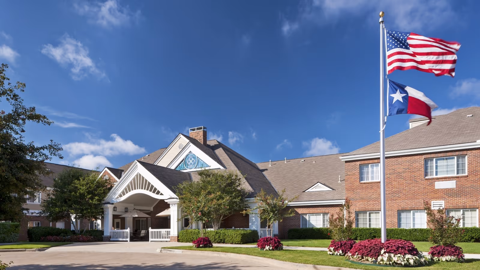 Exterior view of Monarch at Richardson building with flagpoles and landscaped grounds.