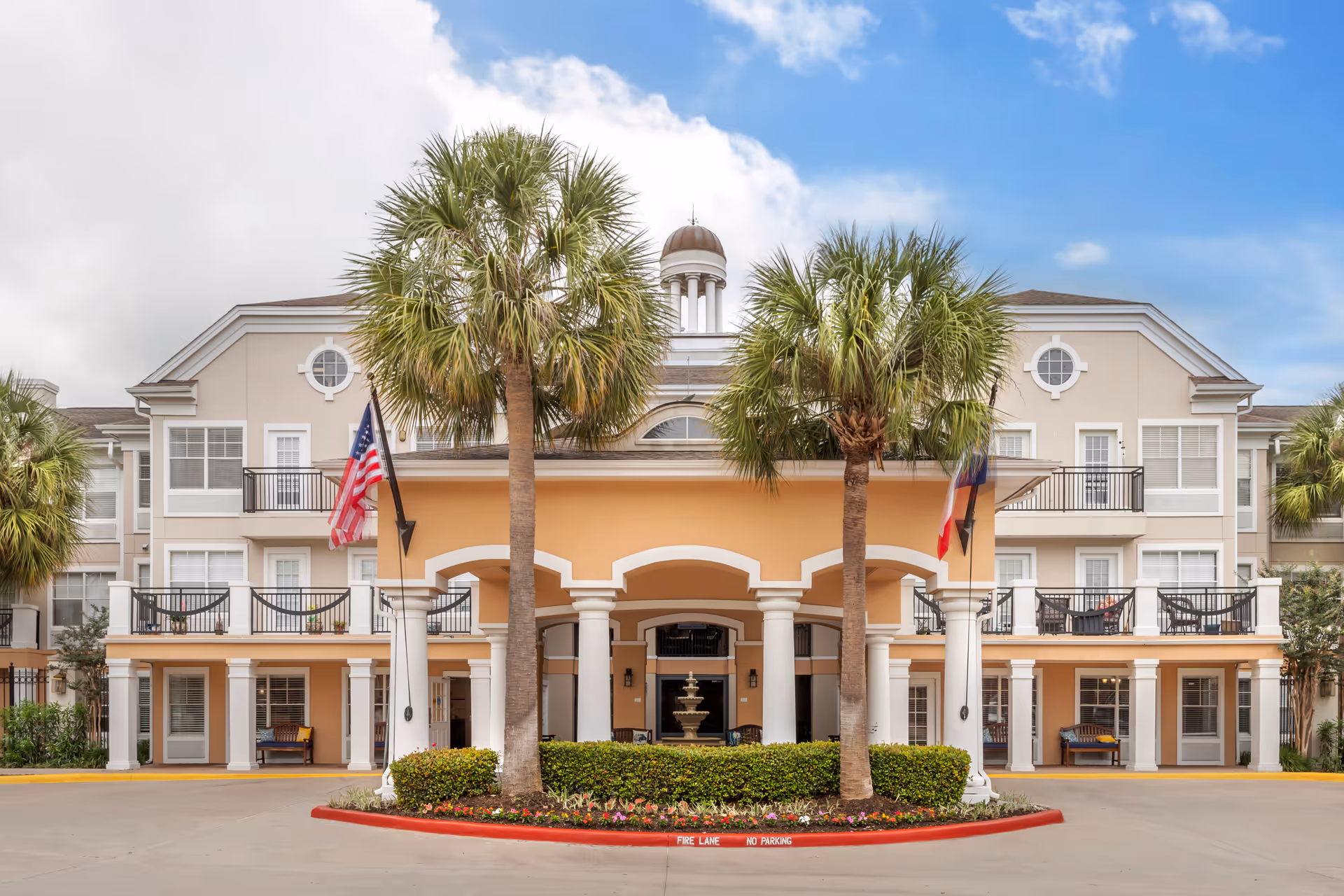 Brookdale Clarksville front entrance with palm trees and flags.