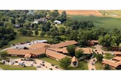 Aerial view of Leonardville Nursing Home campus with brown-roofed buildings, parking, and surrounding trees.