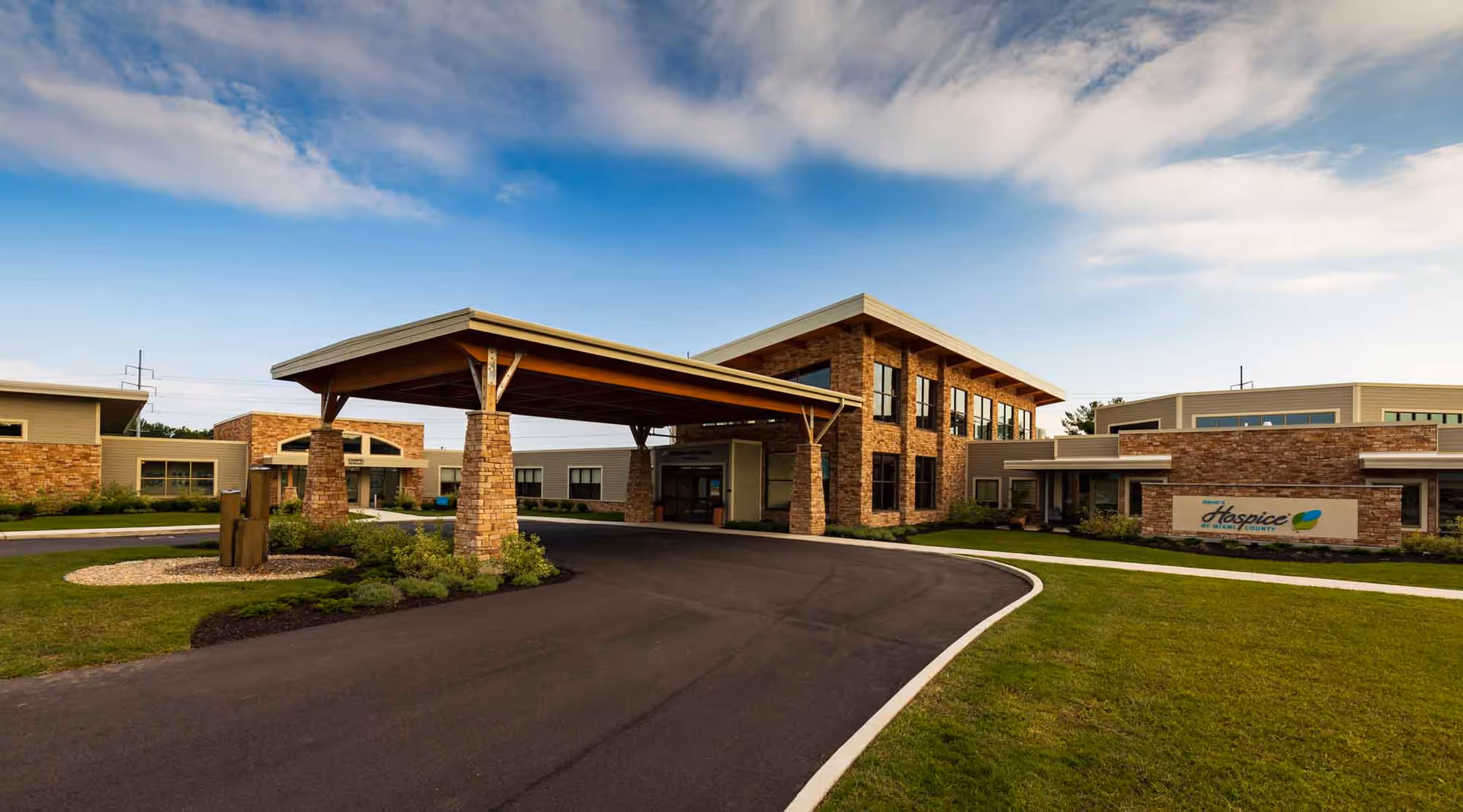 Exterior view of Ohio’s Hospice of Miami County facility with brick entrance and covered drop-off.