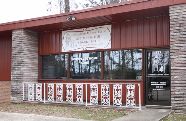 Exterior view of a red building with Complete Home Care signage and decorative railing.