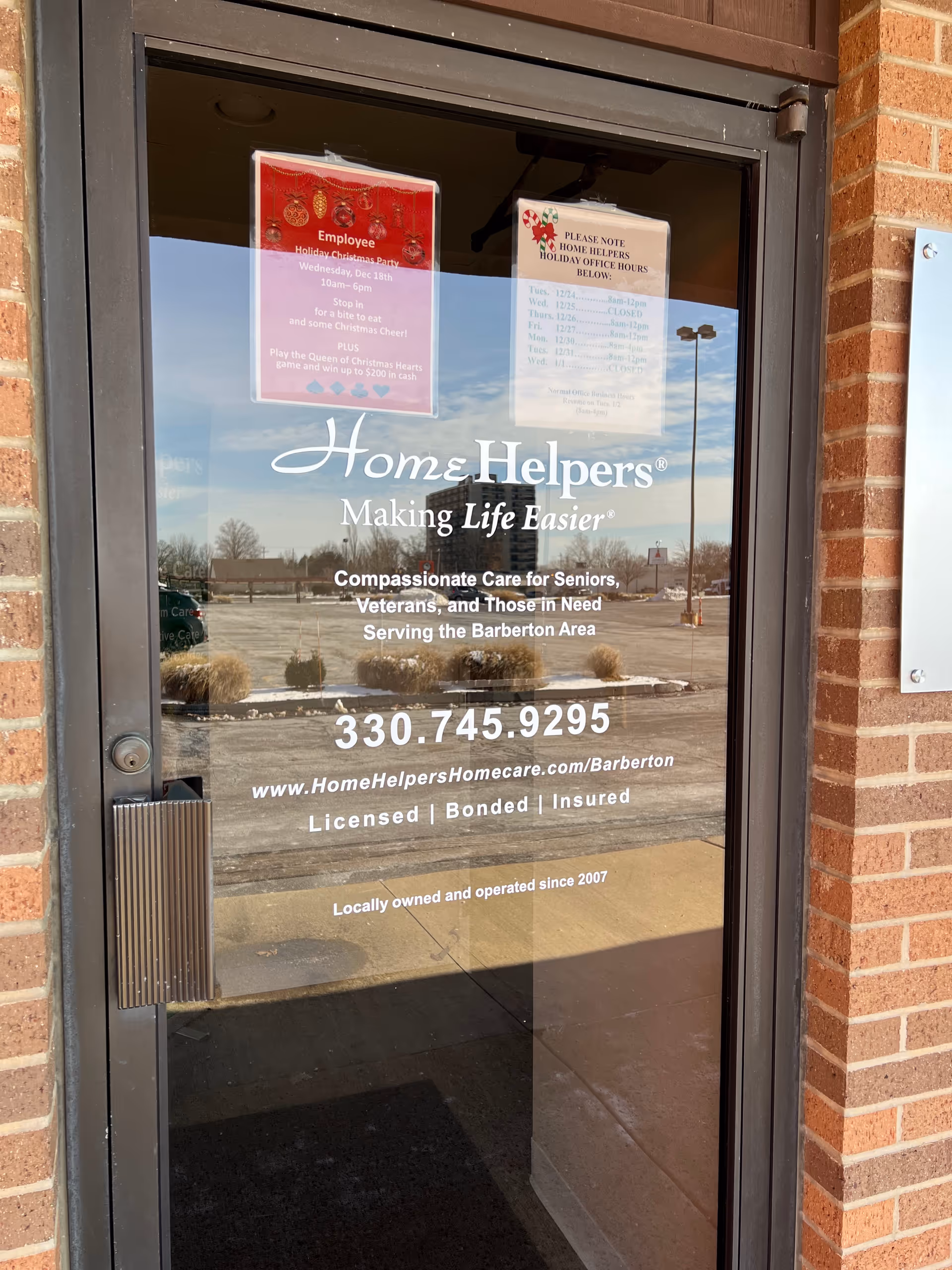 Glass front door displays Home Helpers logo, contact details, and Barberton area care.