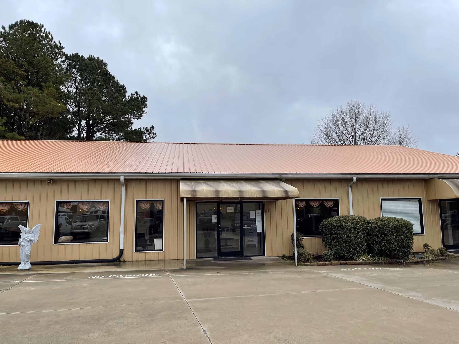 Front view of Haymon Homes senior living facility entrance with beige siding and parking.
