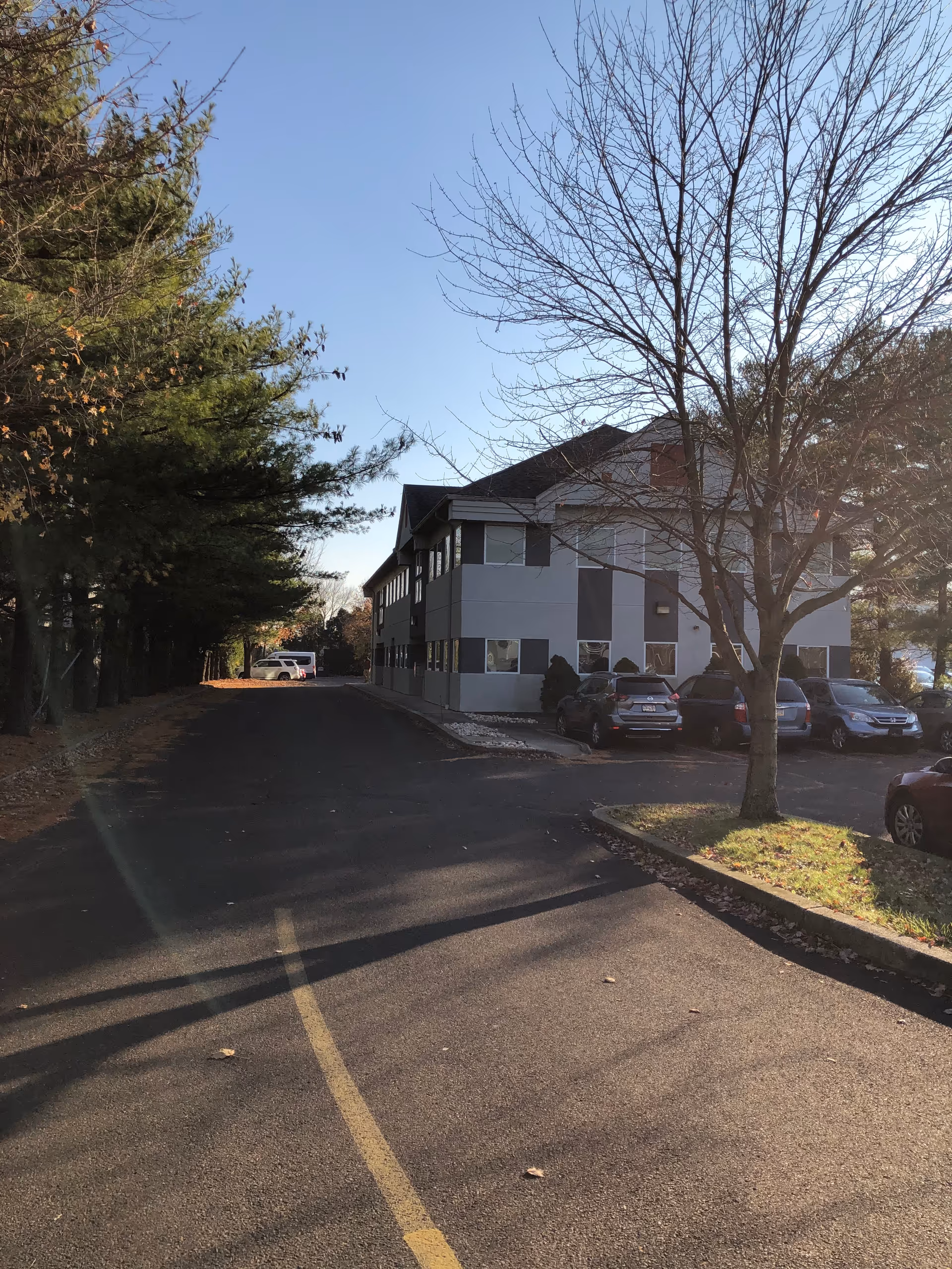 Exterior view of Genesa Home Healthcare and Companion Agency building with parked cars and trees.