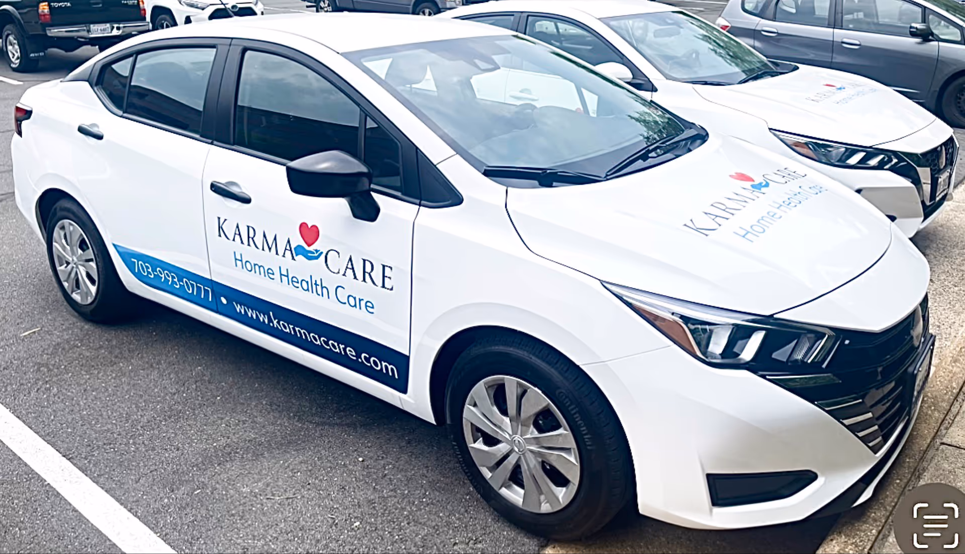 White Karma Care Home Health Care branded car parked in a lot.