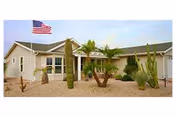 Front view of Clark Residence senior living facility with desert landscaping and an American flag.
