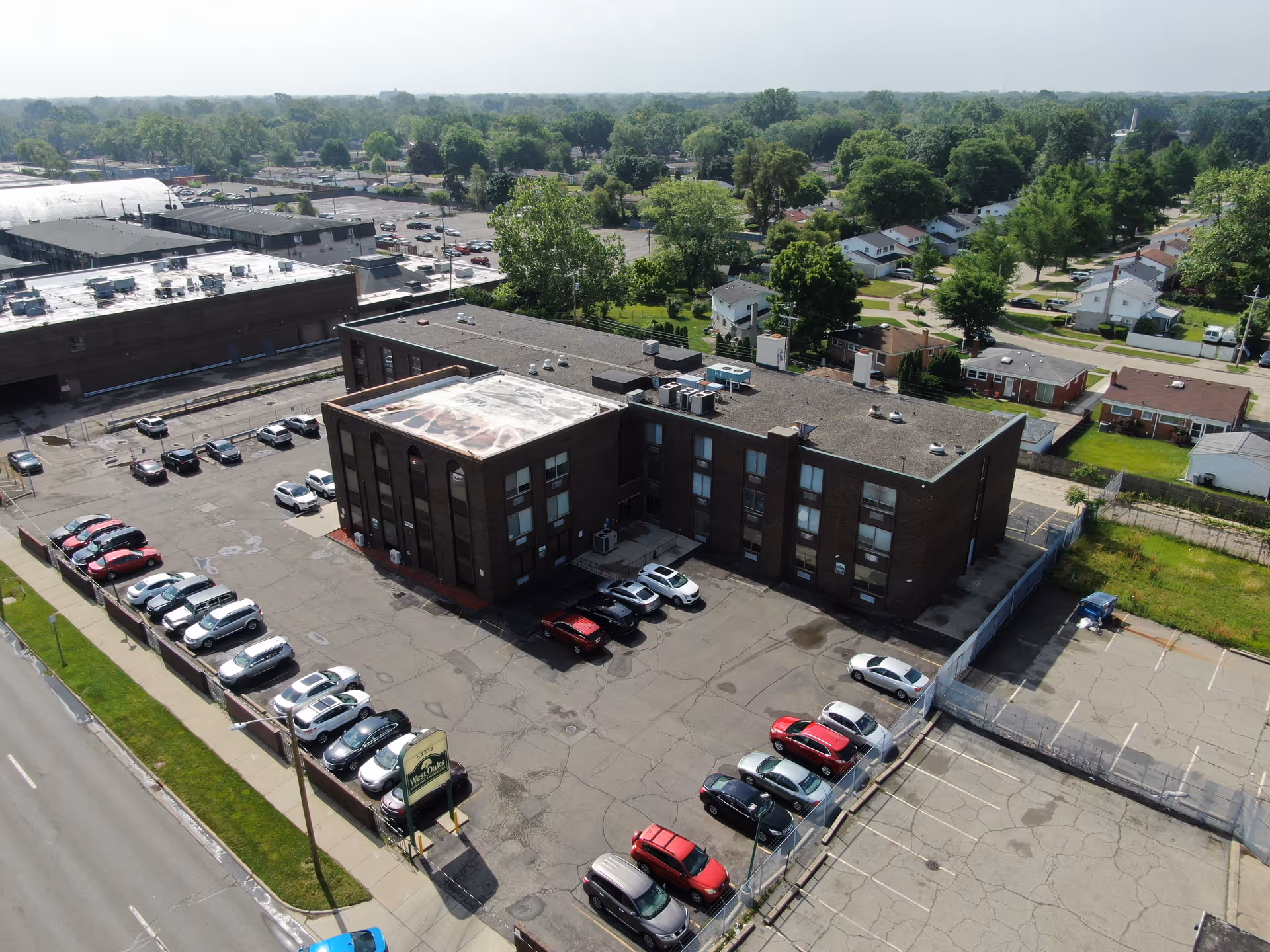 Aerial view of West Oaks Senior Care and Rehab Center, a brick building with parking lot.