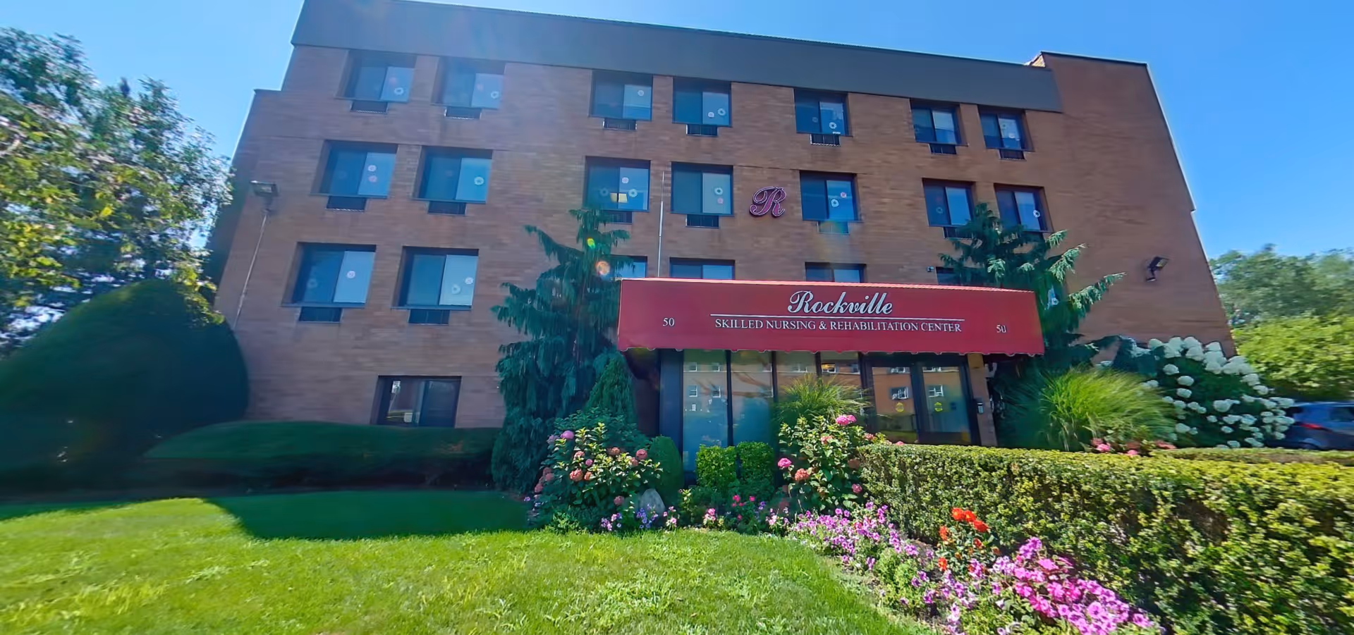 Front view of Rockville Skilled Nursing & Rehabilitation Center building with a red awning.