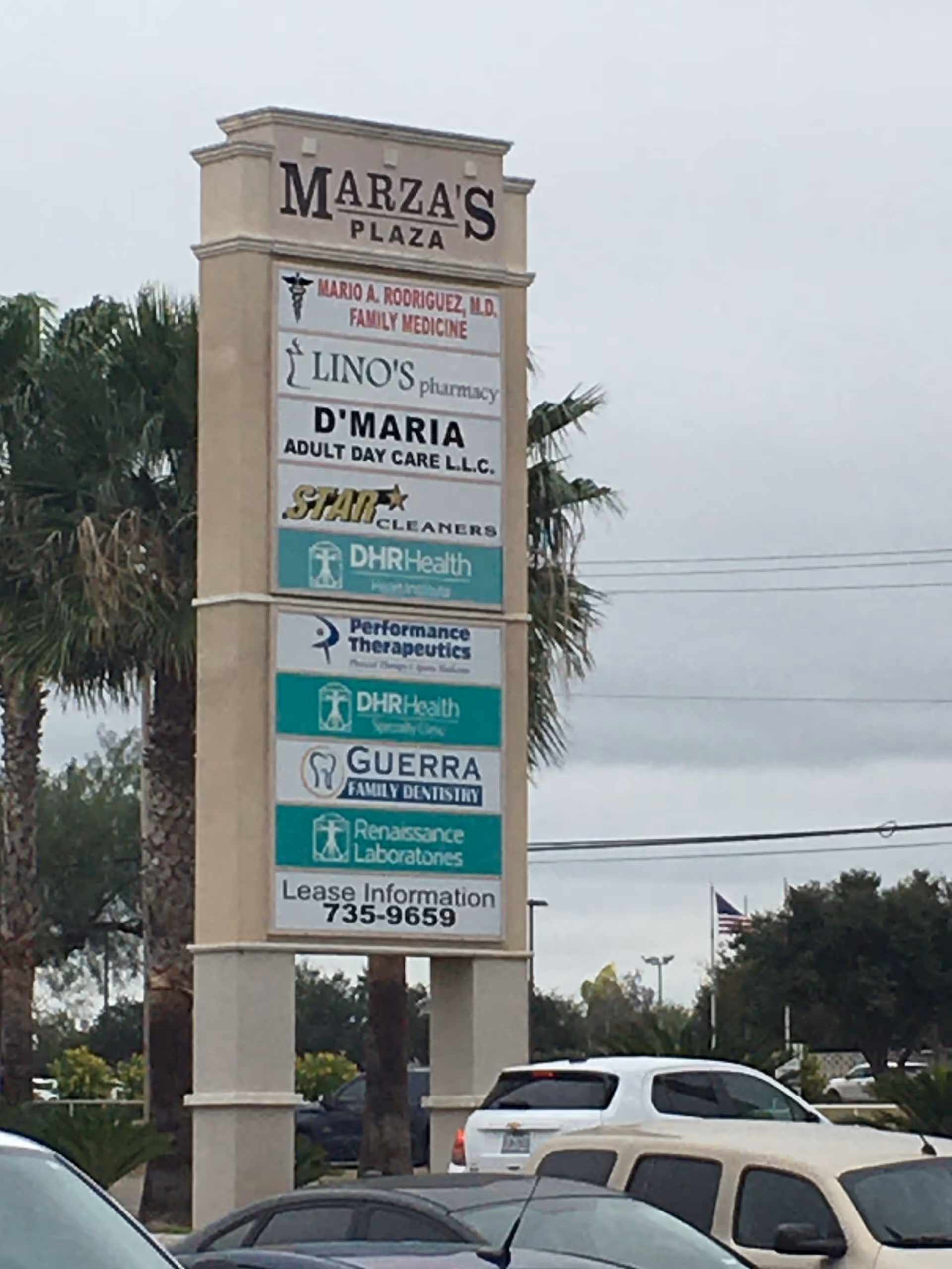 Tall outdoor sign listing multiple businesses at a shopping plaza