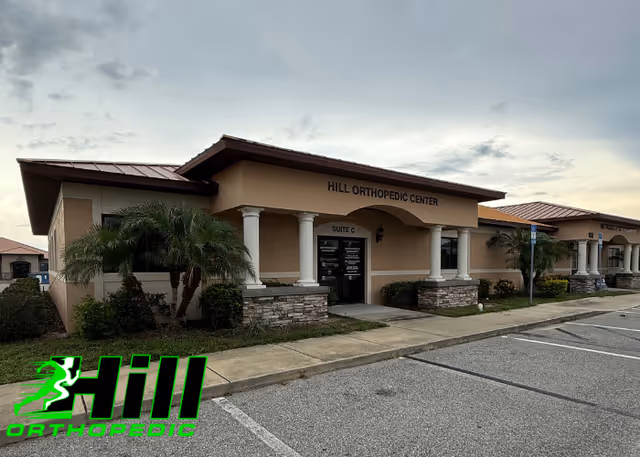 Exterior view of Hill Orthopedic Center with columns and a parking lot.