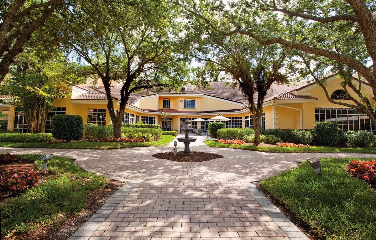 Exterior view of Five Star Premier Residences of Plantation with a circular brick walkway and fountain.