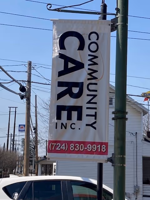 Vertical banner for Community Care Inc. Home Health Services along a street.
