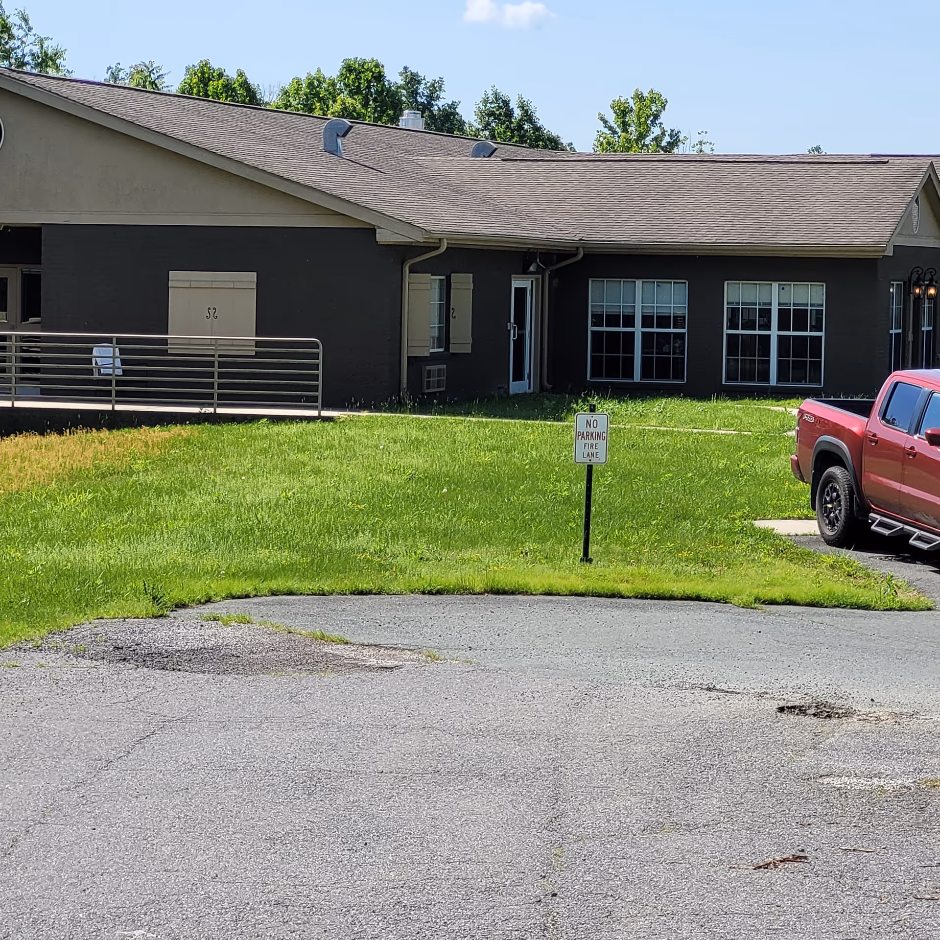Front exterior of Grace Health and Rehab Center of Greene County with ramp and red pickup