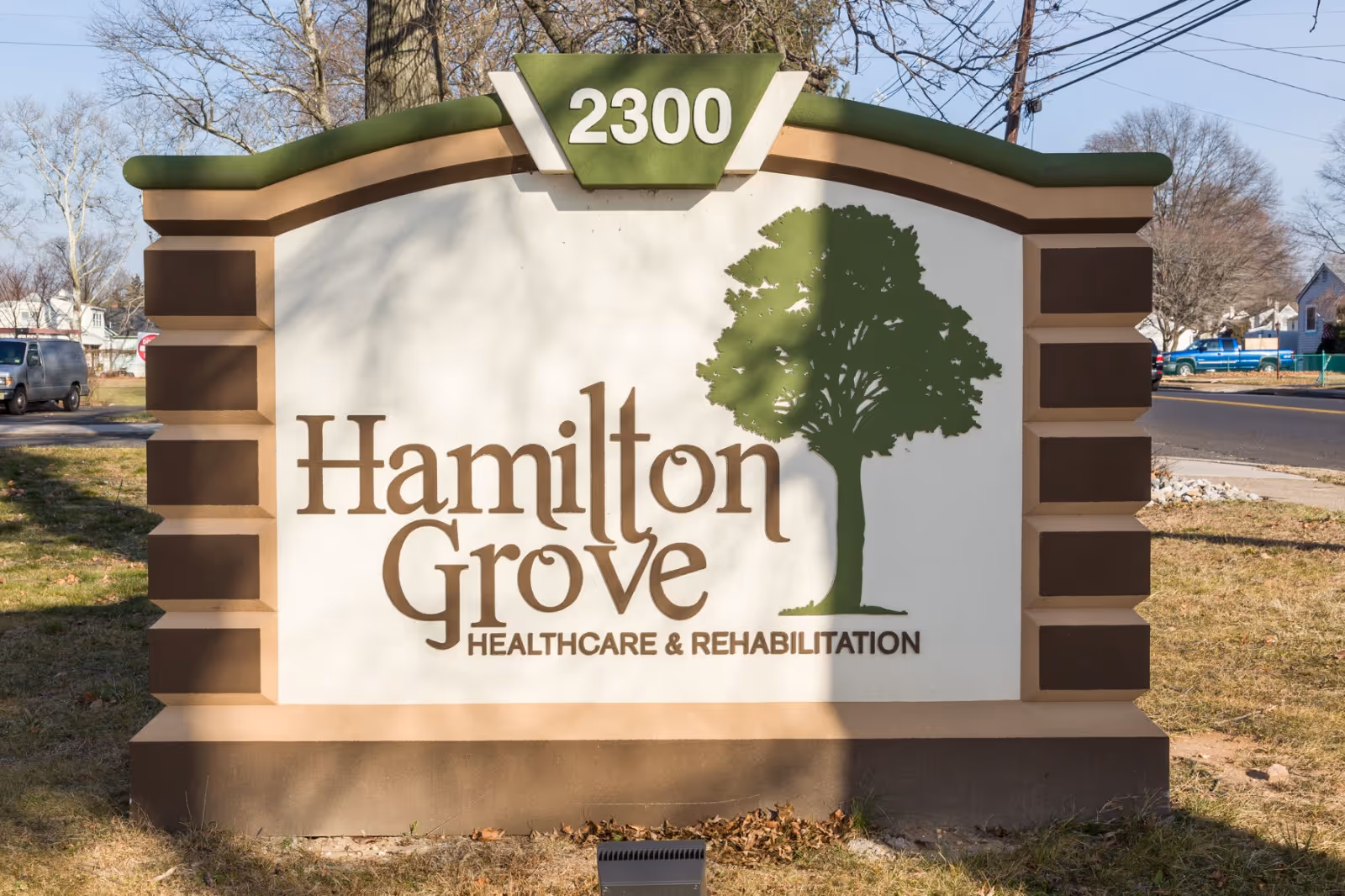Entrance sign for Hamilton Grove Healthcare & Rehabilitation with a tree graphic.