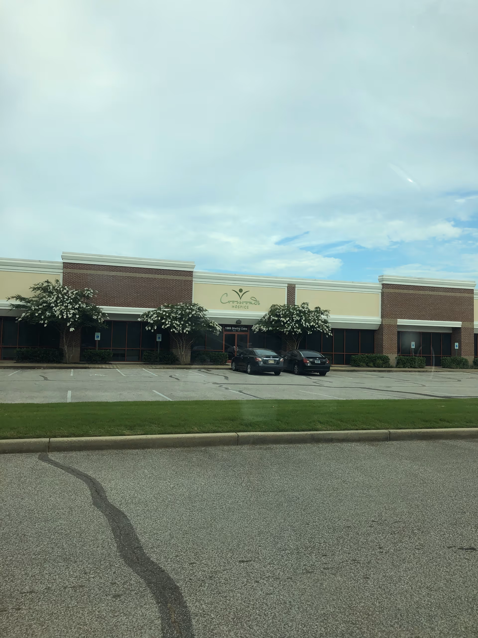 Exterior view of Crossroads Hospice building with parking and trees.
