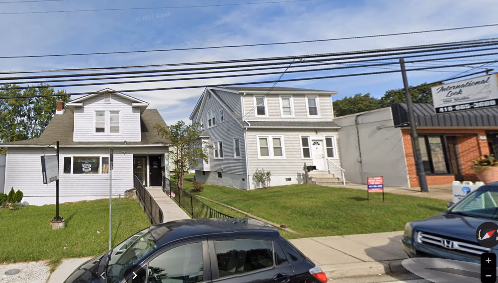 Exterior view of several houses and a storefront along a residential Parkville street.