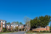 Exterior view of Evergreens at Columbia Town Center building with trees and blue sky.