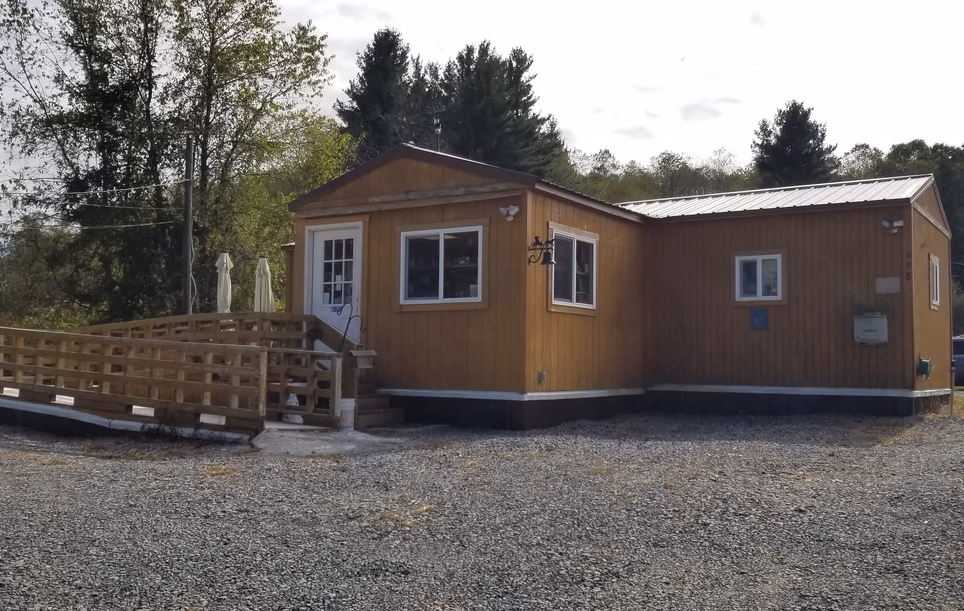 A single wooden clinic building with ramp and surrounding gravel lot.