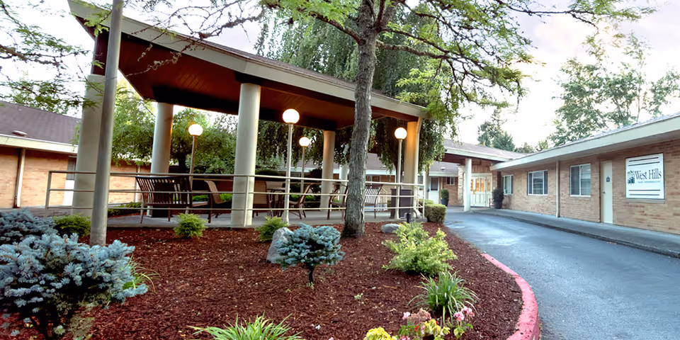 Exterior view of West Hills Health and Rehabilitation with a covered outdoor seating area and landscaping.