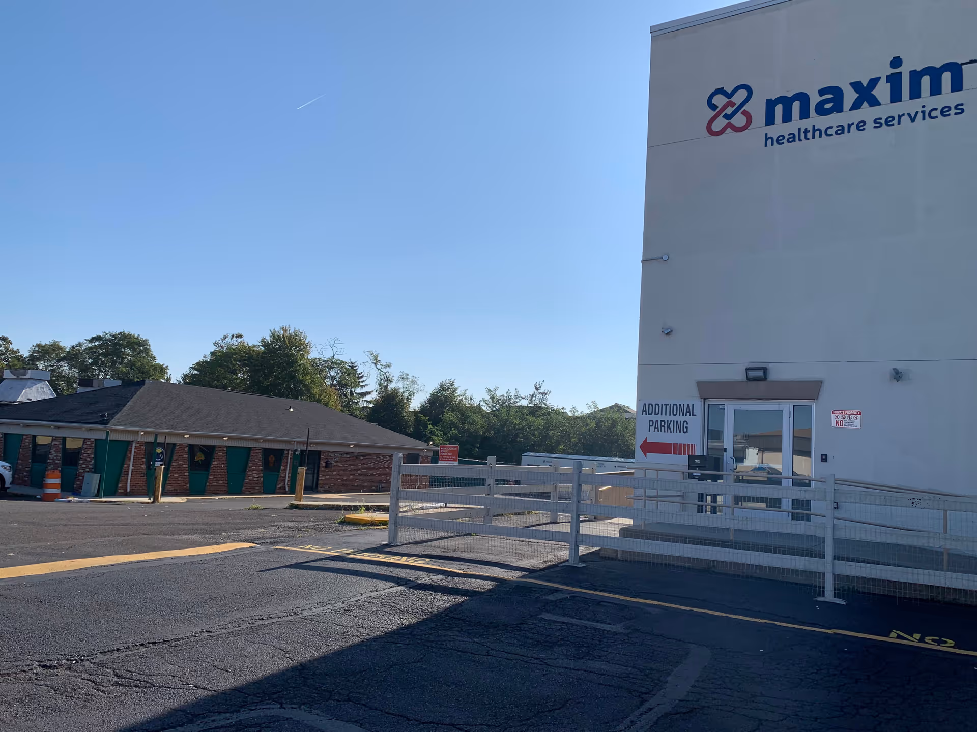 Exterior view of the Maxim Healthcare Services building with a parking lot.