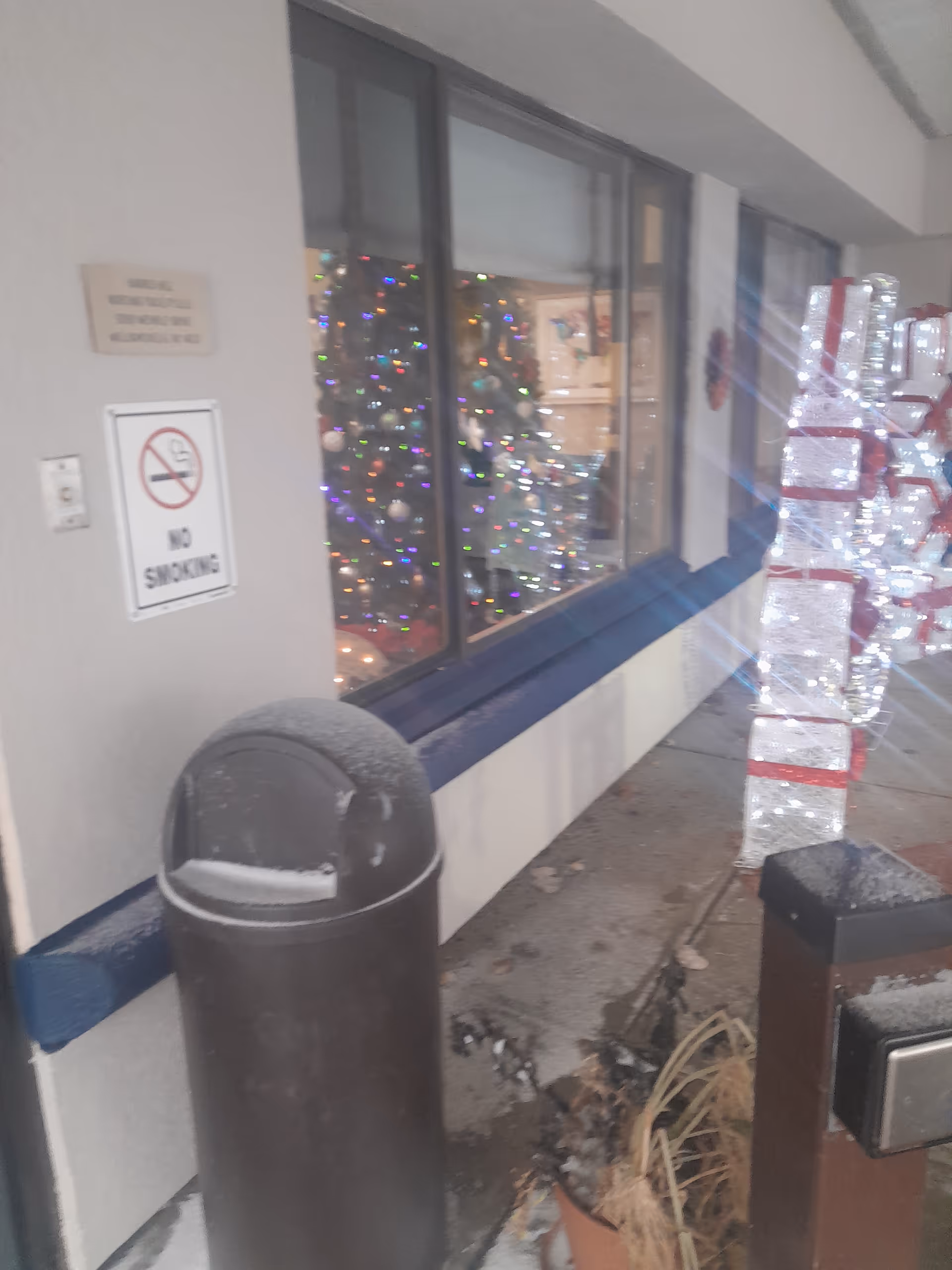 Exterior corridor of Harris Hill Nursing Facility with a window showing holiday lights.