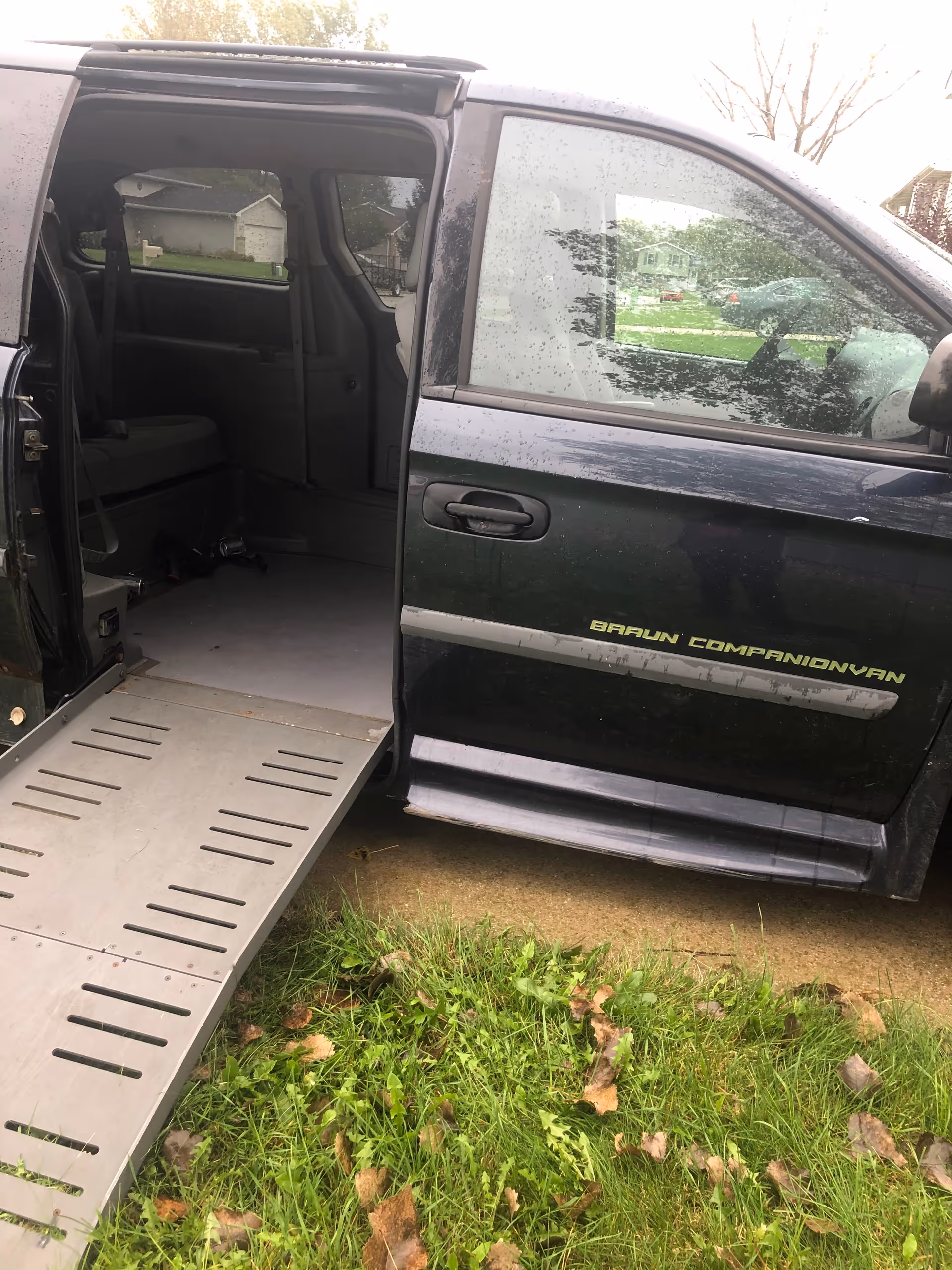 ACL Home Care van with wheelchair ramp extended sits outside on grass.