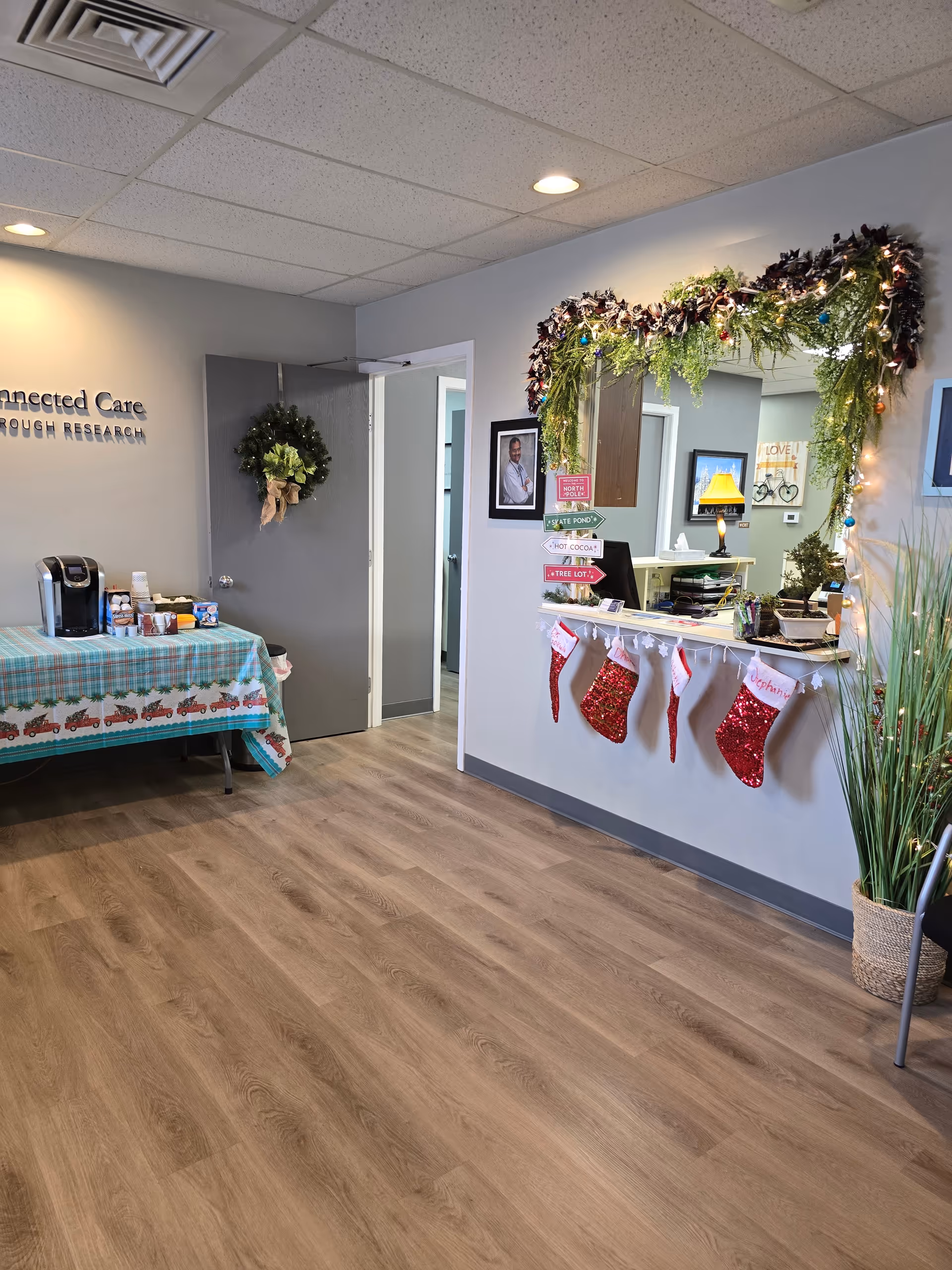 Indoor reception area featuring holiday garland, stockings, a wreath, and a coffee station.
