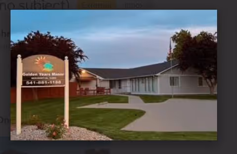 Front exterior of Ashley Manor Senior Living with sign, walkway, and lawn.